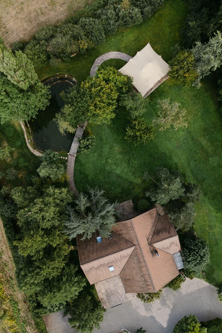Luftaufnahme von Gut Rehbach mit Chalet, Teich, Steg und Stretchzelt