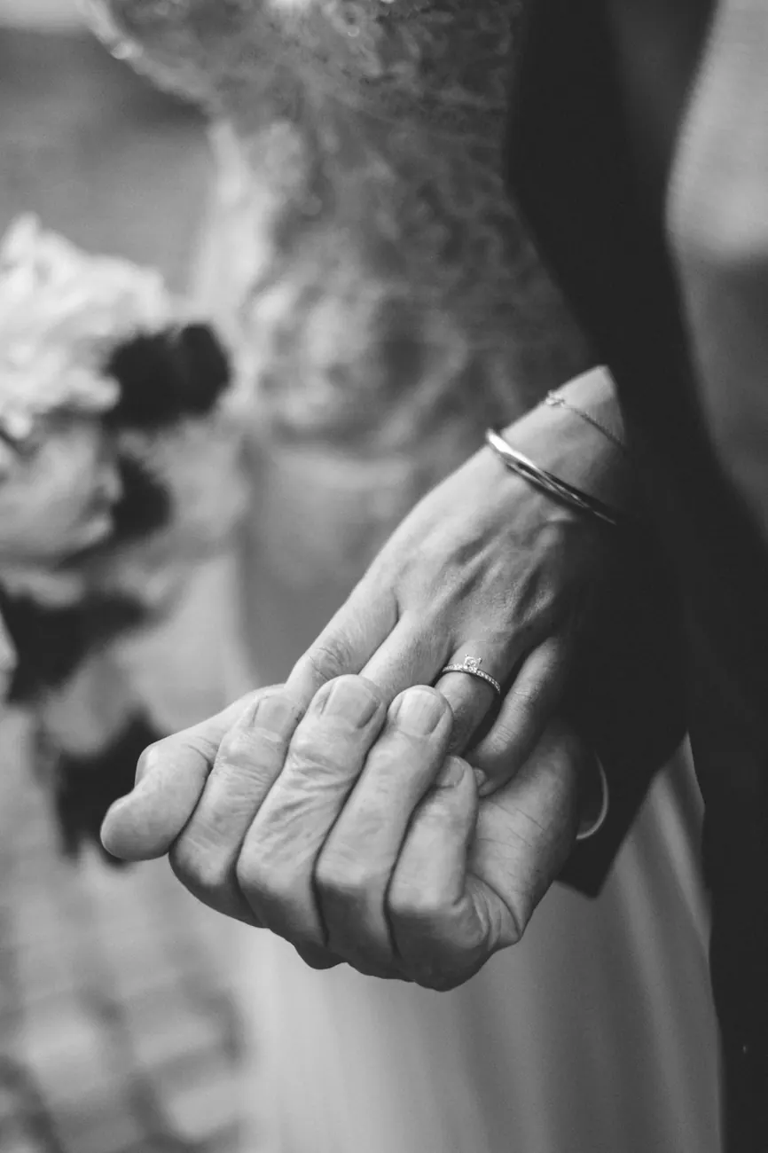 Brautpaar hält sich an den Händen, Ring im Detail, Schwarzweiß