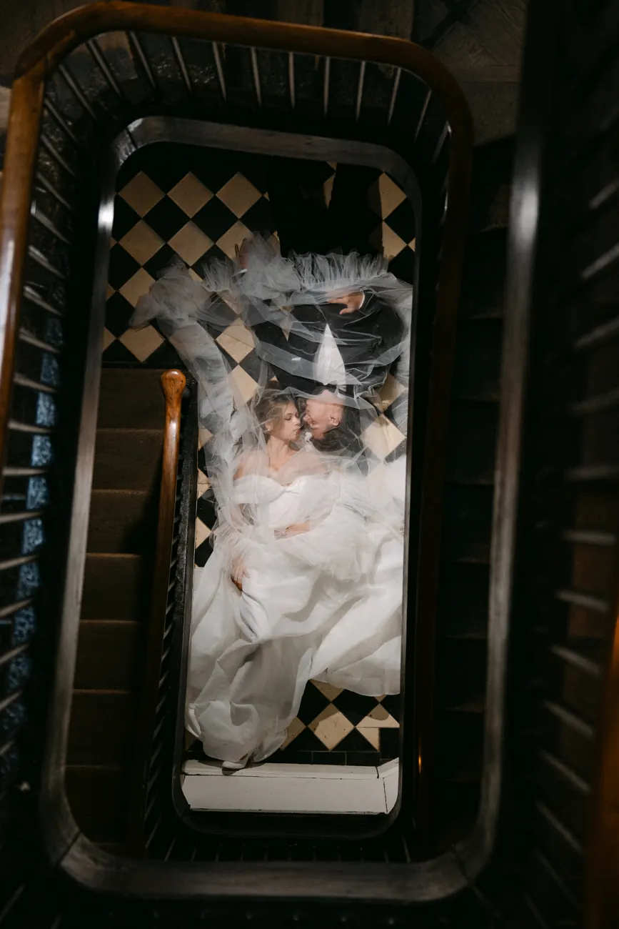 Brautpaar auf dem Schachbrettboden im Treppenhaus des Schlossguts Lautenbach, von oben fotografiert