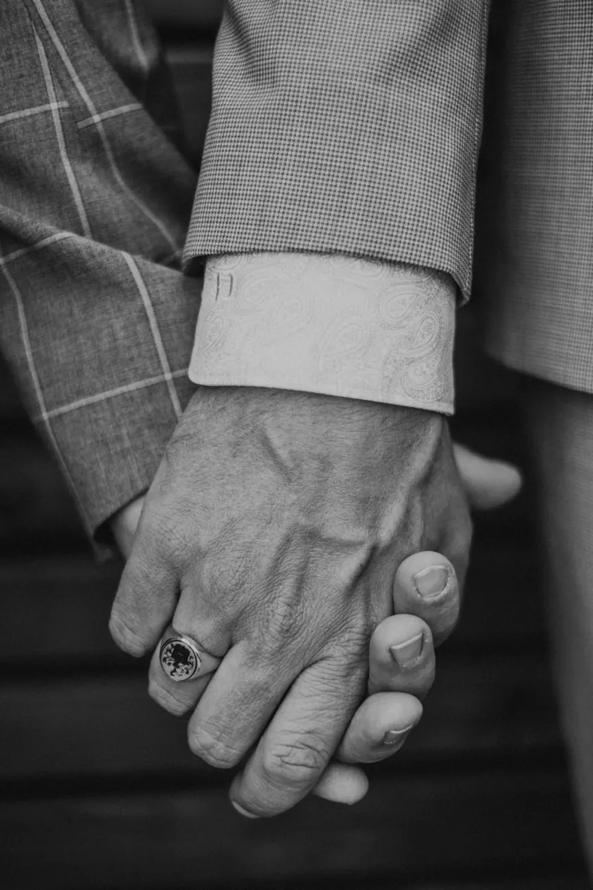 Zwei Männer halten sich bei ihrer Hochzeit an den Händen, Schwarzweiß