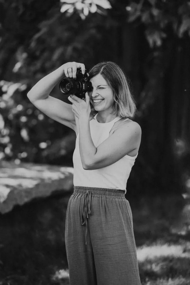 Lisa fotografiert lachend, Schwarzweiß-Porträt